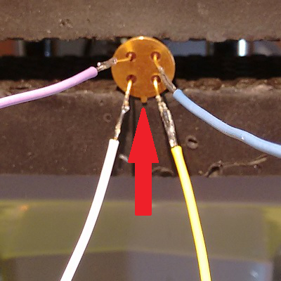 The cover's four wires and the sensor's pins they connect to, with a red arrow marking the tab