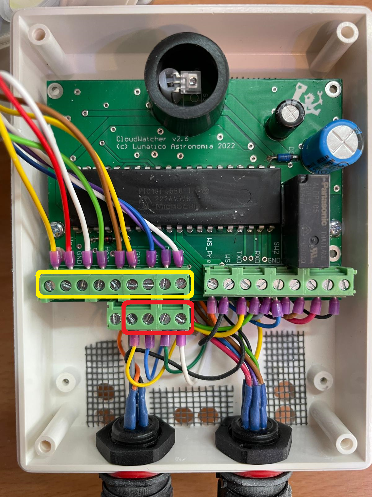 Open CloudWatcher case showing the circuit board, with 9 screws circled in yellow and 4 optional RH/pressure sensor screws circled in red