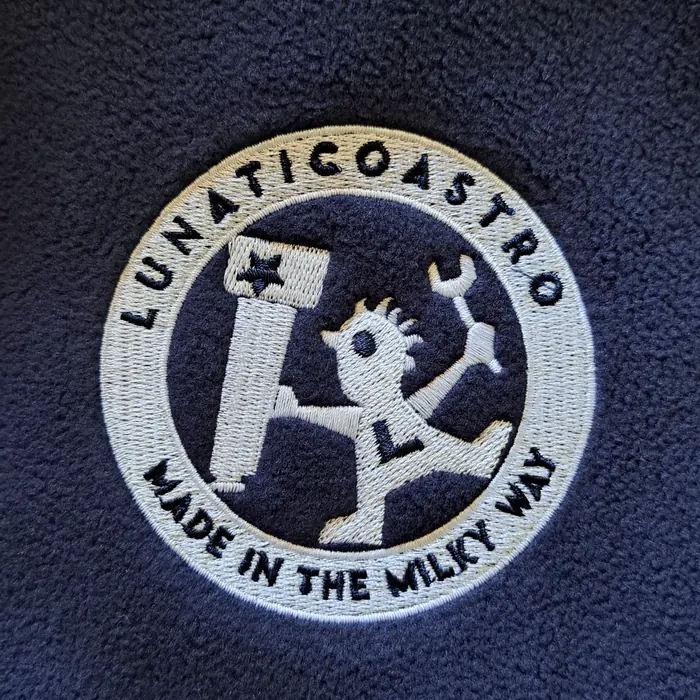 Close-up of the embroidered Lunaticoastro crest: Made in the Milky Way, with Cristobal